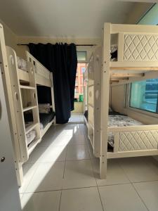 a room with two bunk beds with a window at Ramble Stay Hostel in Dubai