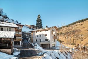 un complejo de apartamentos en un pueblo de montaña en la nieve en Lena Dolomites Gartensuite, en Villnoss