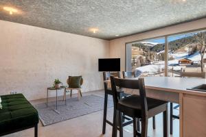 sala de estar con mesa, sillas y ventana en Lena Dolomites Gartensuite, en Villnoss