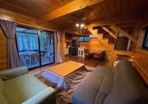 a living room with a couch and a staircase in a cabin at NAKADAKI ART VILLAGE - Vacation STAY 23991v in Shiigi