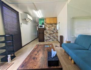 a living room with a blue couch and a kitchen at BULLs Camp - Vacation STAY 56022v in Narusawa