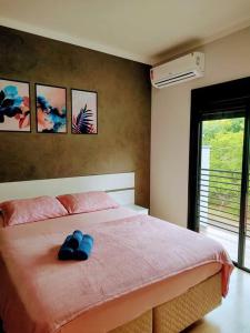 a bedroom with a bed with blue slippers on it at Sobrado para relaxar in Tatuí