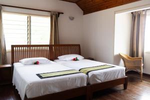 a bedroom with two beds and a window at Bonnen Kare in Grand Anse