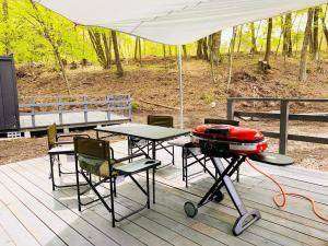 - une table de pique-nique avec un grill et des chaises sur une terrasse dans l'établissement BULLs Camp - Vacation STAY 56020v, à Narusawa