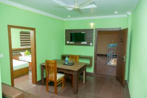 a room with a table and chairs and a bedroom at Hamsted in Kottakkal