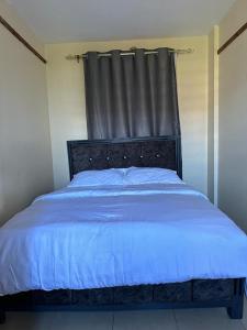 ナイロビにあるStelvic One Bedroom Airbnbのベッドルーム1室(黒いヘッドボード付きのベッド1台付)