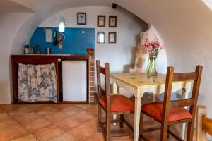 CalascioにあるLa Taberna di Rocca Calascioのキッチン(テーブル、椅子、花瓶付)