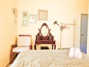1 dormitorio con cama, espejo y silla en Mossy Forest Family Retreat 2, Kea Farm Brinchang en Cameron Highlands