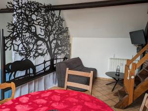 uma sala de estar com um mural de árvore na parede em LE GITE DE RICHEMONT em Lachapelle-Saint-Pierre