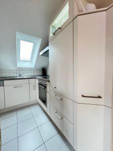 a white kitchen with white cabinets and a window at Ferienapartment Huber in Oberkirch