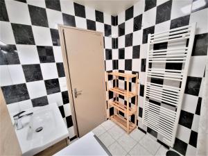 bagno con parete a scacchi in bianco e nero di Appart' convivial 3 Ch 73m² à proximité de Paris a Châtillon