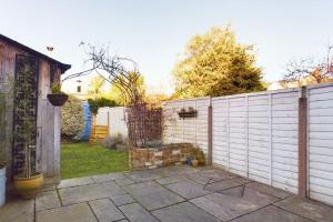 a backyard with a white fence and a yard at Melody Rowe One Bed Free Wi-Fi Garden Fireplace 