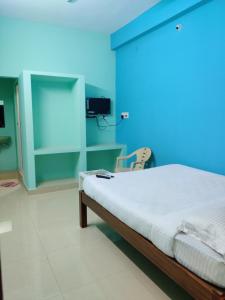 a bedroom with a bed with a blue wall at ‌‌Florence guest house in Puducherry