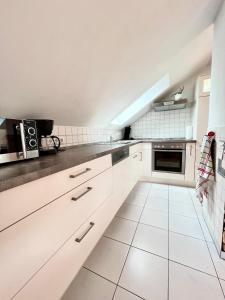 uma cozinha branca com armários e electrodomésticos brancos em Ferienapartment Huber em Oberkirch