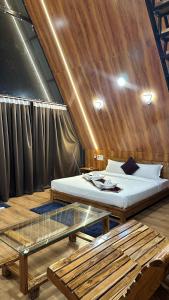 RehtiにあるLotuslap Resortのベッドとガラスのテーブルが備わる客室です。