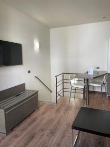 Select Executive Residence في فلورنسا: غرفة معيشة مع طاولة وتلفزيون على الحائط