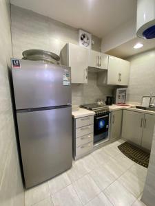 a kitchen with a stainless steel refrigerator in it at منتجع شمس in Ilbaras