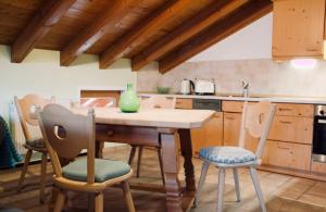 Ferienwohnung Am Loferwasser في اريت ايم فينكل: مطبخ مع طاولة وكراسي خشبية +8 صور