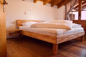 een slaapkamer met een houten bed in een kamer bij Ferienwohnung Am Loferwasser in Reit im Winkl