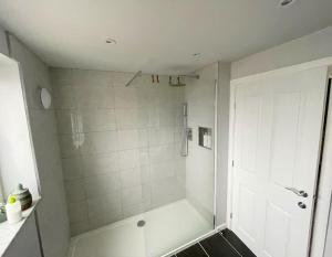 uma casa de banho branca com um chuveiro. em House in Ebbw Vale em Ebbw Vale