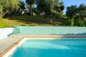 een blauw zwembad met een stoel naast een hek bij Number 21 in Mogliano