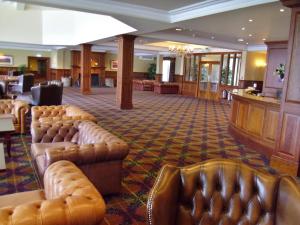 a hotel lobby with leather couches and a bar at Ardgartan Hotel in Arrochar