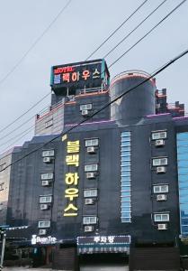 un edificio con un cartel encima en Buantreehotel Blackhouse, en Buan