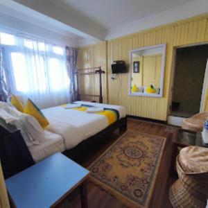 een hotelkamer met een bed en een bank bij Hotel Aliment Darjeeling in Darjeeling