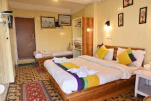 een slaapkamer met een groot bed en handdoeken bij Hotel Aliment Darjeeling in Darjeeling