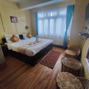a hotel room with a bed and a window at Hotel Aliment Darjeeling in Darjeeling