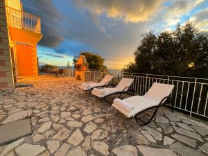 a group of chairs sitting on a stone patio at Villa Kaminia Rose private pool & Jacuzzi in Ratzaklíon