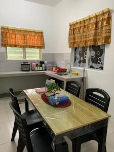 cocina con mesa de madera con sillas y fregadero en AA Burger Homestay for Musliim Only en Banting