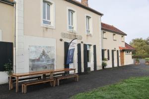 un banco de madera sentado fuera de un edificio en Auberge de Jeunesse HI Genêts en Genêts