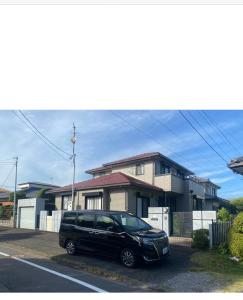 a black car parked in front of a house at ゲストハウス宮崎 guesthouse miyazaki バックパッカー向け個室旅人宿 P有 in Miyazaki