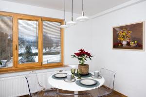 a white dining room with a white table and chairs at Dzīvoklis Kastaņas in Kaibala