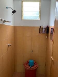 uma casa de banho com um chuveiro e uma lata de lixo vermelha em AA Burger Homestay for Musliim Only em Banting