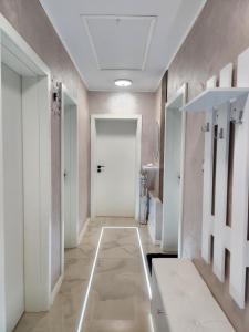 korytarz z białymi drzwiami i podłogą wyłożoną kafelkami w obiekcie Къща за гости Vip House 
