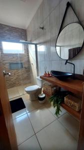ein Badezimmer mit einem WC, einem Waschbecken und einem Spiegel in der Unterkunft Vivenda Bela Vista in Boituva