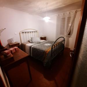 een slaapkamer met een bed, een tafel en een raam bij le bolca in Sausses