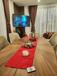 a large wooden table with a red table cloth at Къща за гости Vip House 