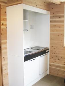 a kitchen with white cabinets and a sink at Hirugano Kogen Cottage Park Shikinosato - Vacation STAY 23984v in Shōgahora