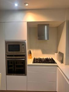 a kitchen with a stove and a microwave at Spacious Central London flat - 2BHK in London