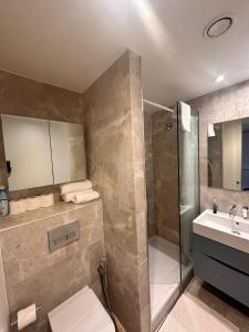 a bathroom with a shower and a toilet and a sink at Spacious Central London flat - 2BHK in London