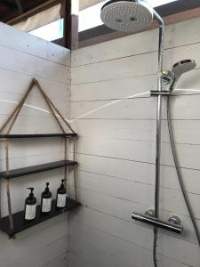 eine Dusche im Bad mit 3 Flaschen auf Regalen in der Unterkunft FARMER'S FIELDZ - Vacation STAY 42161v in Hongō