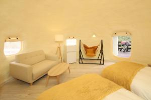 ein Schlafzimmer mit einem Bett, einem Sofa und einem Stuhl in der Unterkunft ASOGUNI Glamping - Vacation STAY 42307v in Oguni