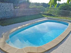 een groot zwembad met blauw water in een achtertuin bij Villa gabrielle in Châteauponsac