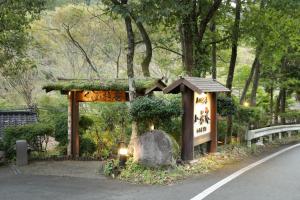 a garden with a sign and a rock in the road at ASOGUNI Glamping - Vacation STAY 42112v in Oguni