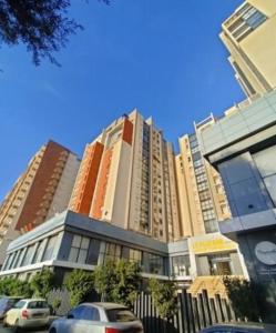 un edificio alto con macchine parcheggiate di fronte di Élégance et confort à Cheraga a Alger
