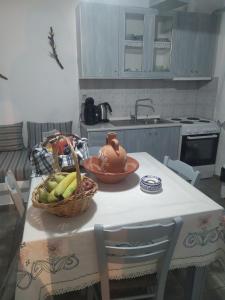 a kitchen with a table with a basket of bananas at Mandrakia house in Mandrakia