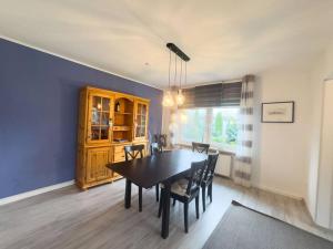 a dining room with a black table and chairs at Haus Glücksfang in Hooksiel in Wangerland